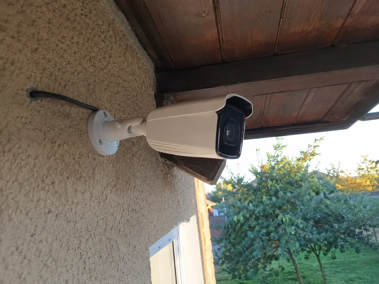 Žičana spoljna IP kamera ispod strehe kuće sa UTP kablom
