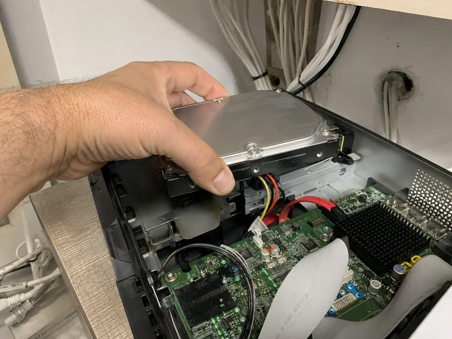 Ruka postavlja hard disk u otvoren mrežni snimač video nadzora
