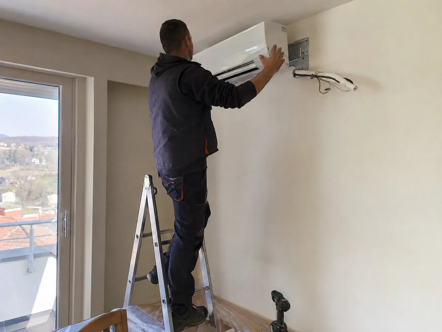 Instalater montira unutrašnju jedinicu klime na zid stana
