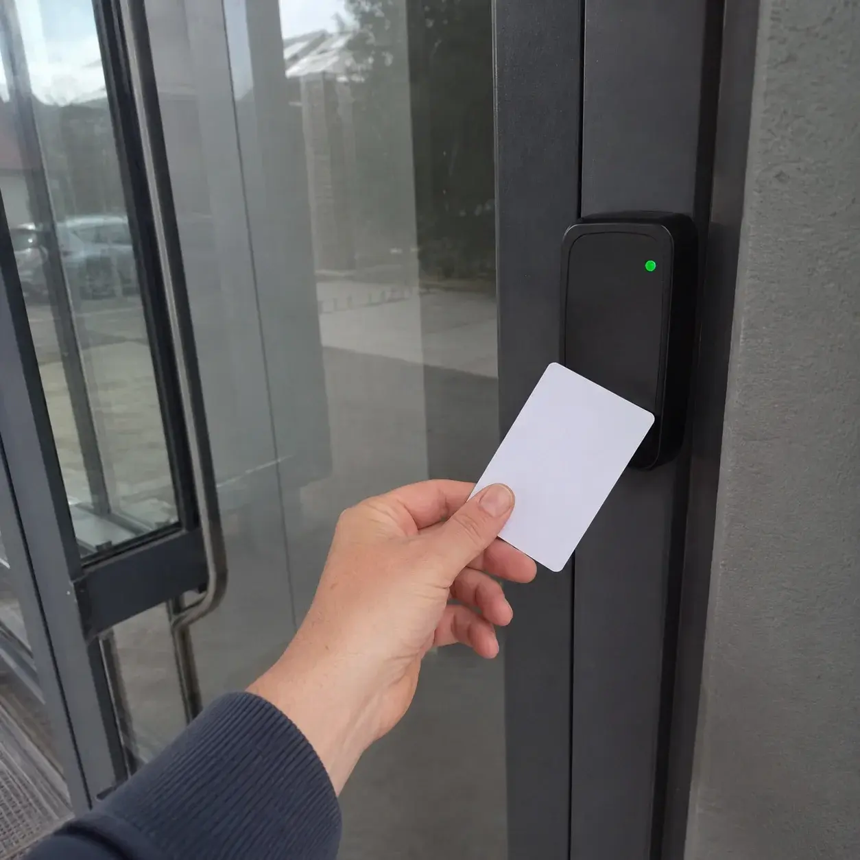 Zaposlena prinosi RFID karticu čitaču pored ulaznih vrata