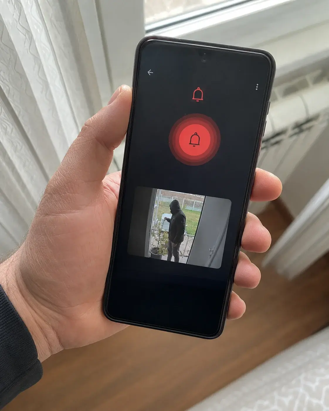 Telefon prikazuje obaveštenje o alarmu zajedno sa slikom sa kamere