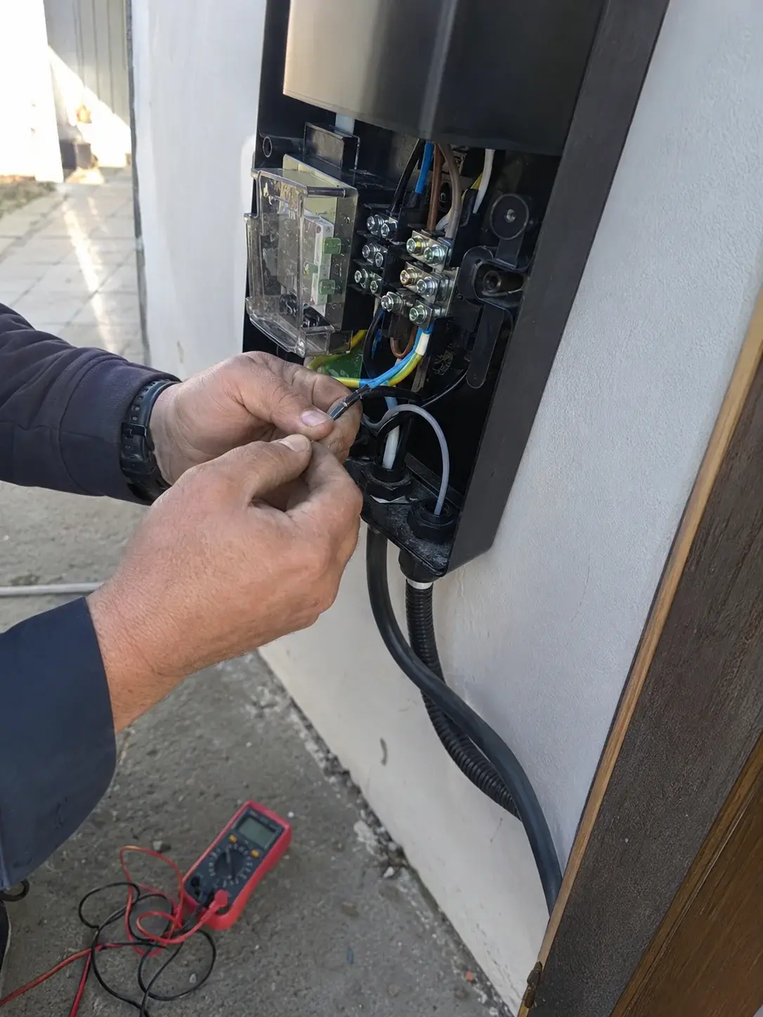 Elektroinstalater povezuje kablove u kućištu wallbox punjača