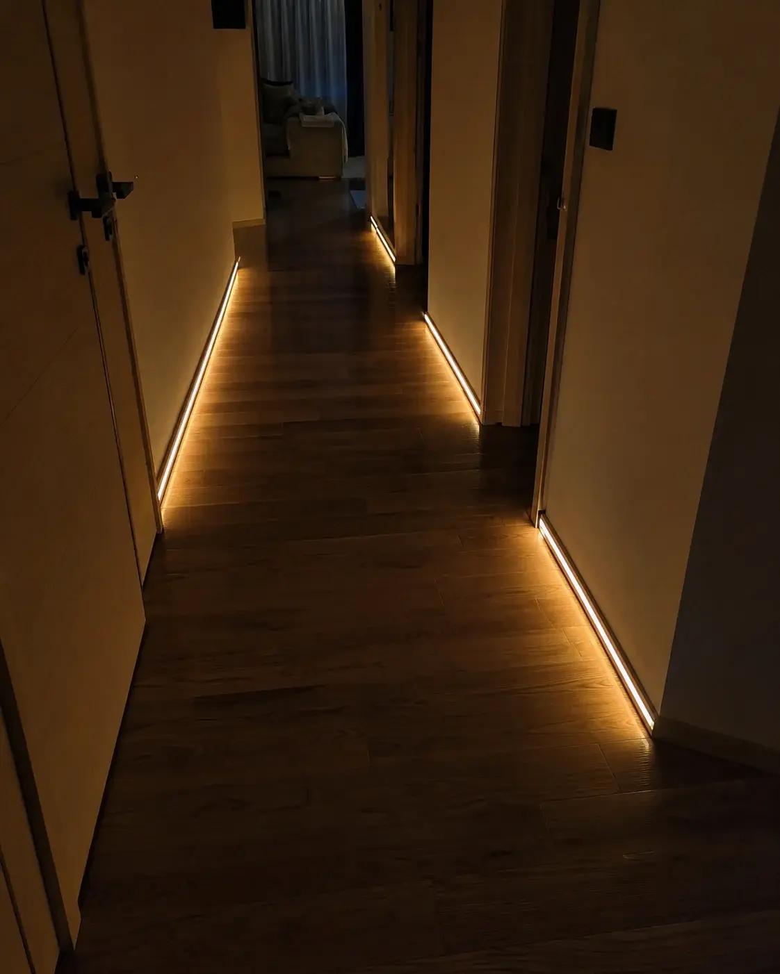 Hodnik noću sa LED trakom pri podu koja se upalila na prolaz