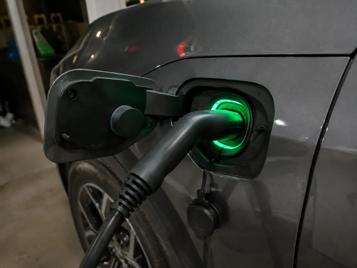 Priključak kućnog punjača utaknut u port električnog automobila