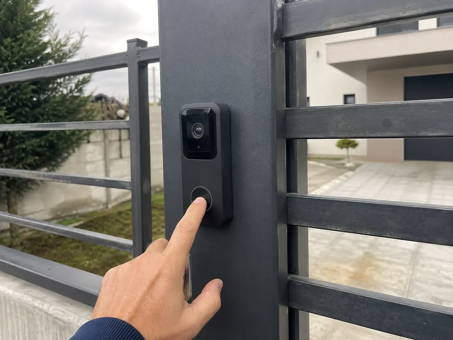 Posetilac pritiska taster video interfona na kapiji kuće
