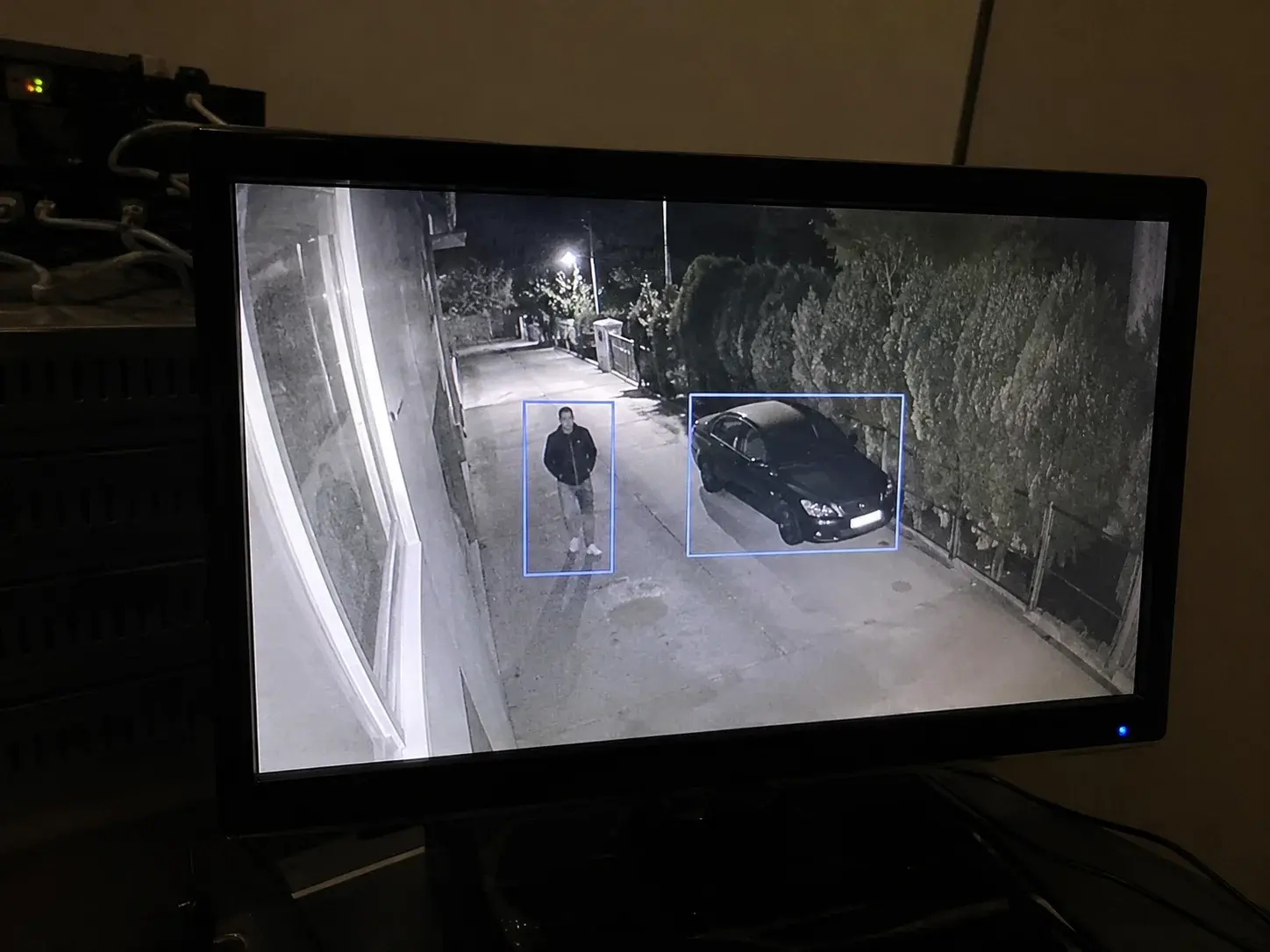 Noćni snimak sa osobom i automobilom uokvirenim zasebnim okvirima detekcije