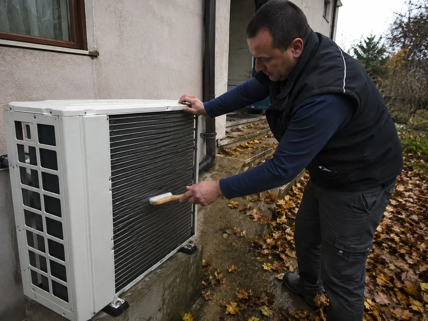 Serviser čisti lamele spoljne jedinice toplotne pumpe u jesen