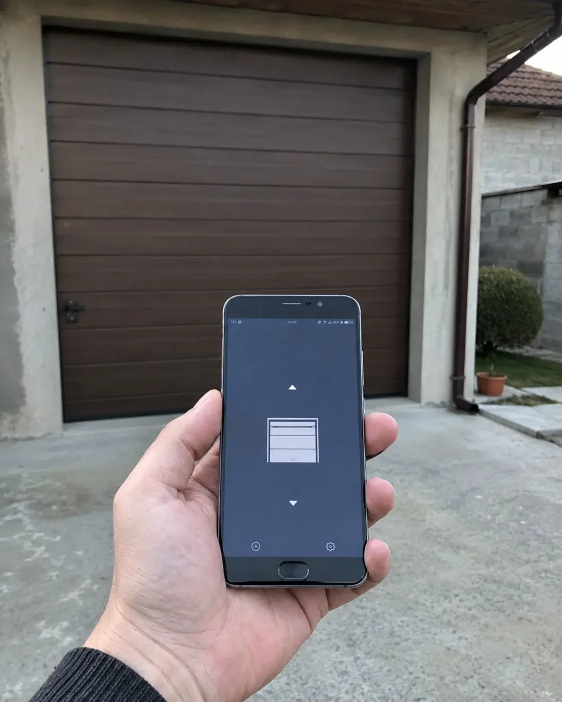 Telefon ispred garažnih vrata prikazuje njihov status zatvorenosti