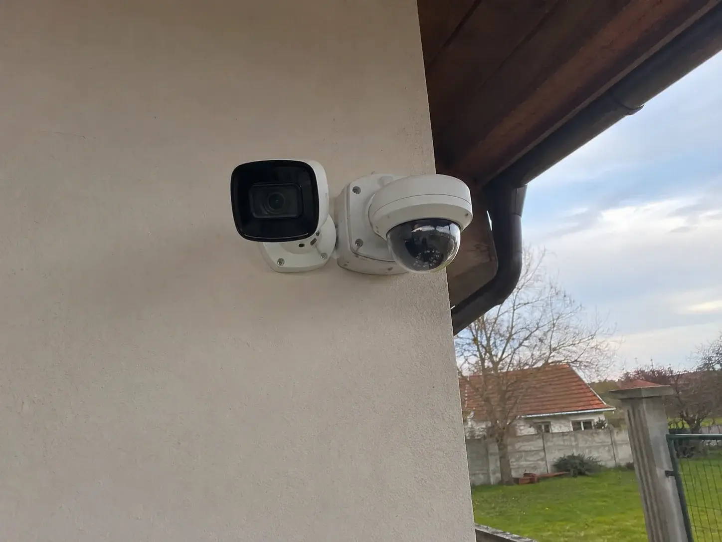 Moderna IP i klasična analogna kamera postavljene jedna pored druge na zidu