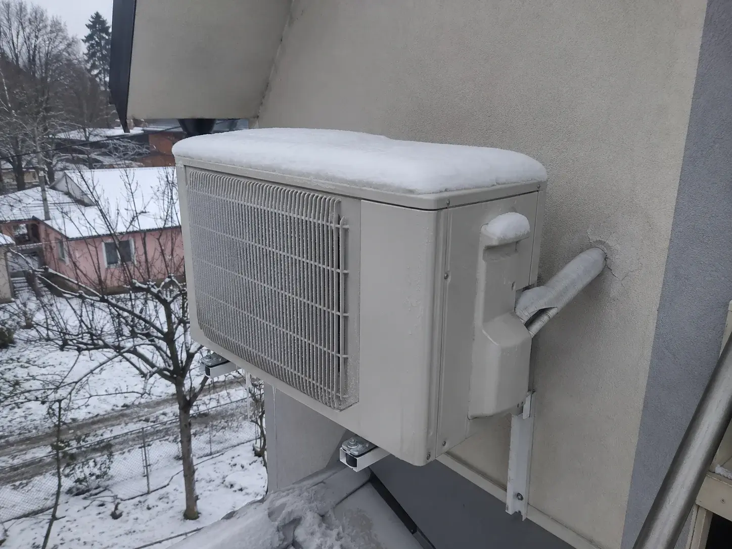 Spoljna jedinica klime sa snegom i ledom na lamelama zimi